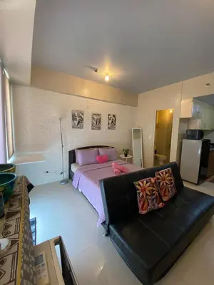 a bedroom with a bed and a couch in it at Modern Studio Unit at One Palm Tree Villas near NAIA & Resortsworld in Manila