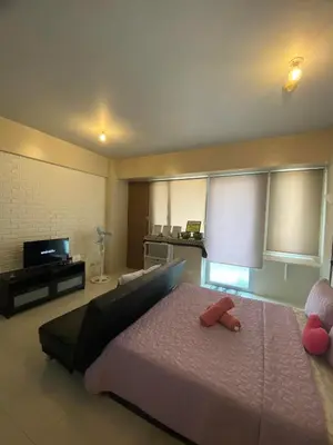 a bedroom with a bed with two stuffed animals on it at Modern Studio Unit at One Palm Tree Villas near NAIA & Resortsworld in Manila