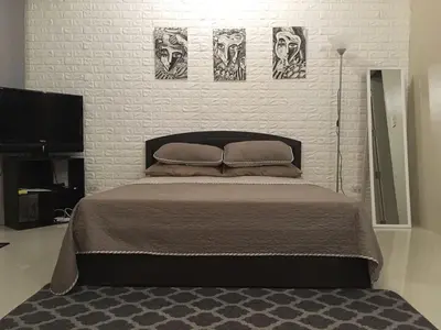 a bedroom with a bed with three pictures on the wall at Modern Studio Unit at One Palm Tree Villas near NAIA & Resortsworld in Manila