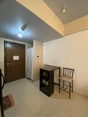 a room with a table and a chair and a door at Modern Studio Unit at One Palm Tree Villas near NAIA & Resortsworld in Manila