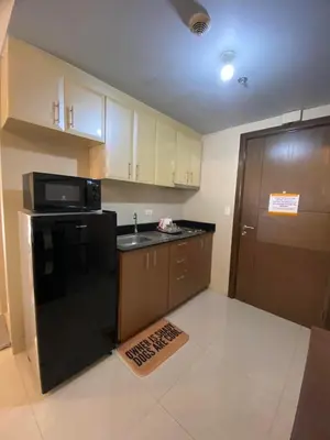 a kitchen with a black refrigerator and a microwave at Modern Studio Unit at One Palm Tree Villas near NAIA & Resortsworld in Manila