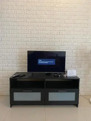 a black entertainment center with a flat screen tv on top at Modern Studio Unit at One Palm Tree Villas near NAIA & Resortsworld in Manila