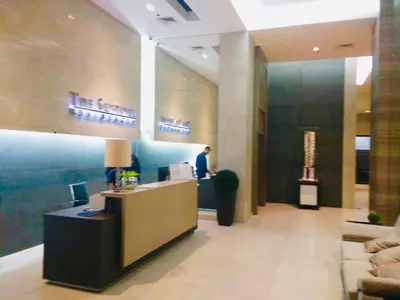 a man standing at a counter in a lobby at The Sentinel Residences Suite in Manila