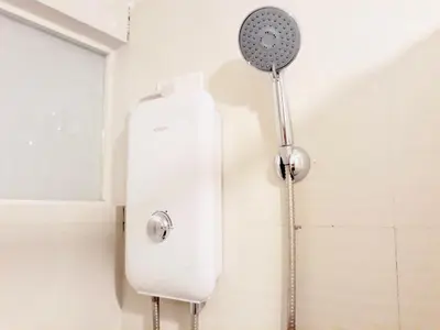 a shower in a bathroom with a shower head at The Sentinel Residences Suite in Manila