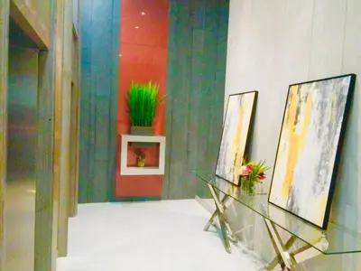 a room with two paintings and a glass table at The Sentinel Residences Suite in Manila