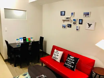 a living room with a red couch and a table at The Sentinel Residences Suite in Manila