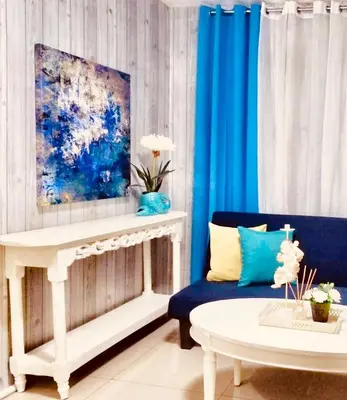 a living room with a blue couch and a table at Super Cute Hampton Suites in Imus