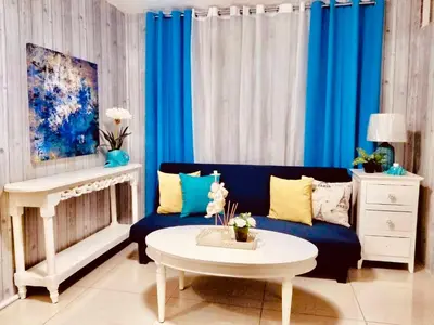 a living room with a blue couch and a table at Super Cute Hampton Suites in Imus