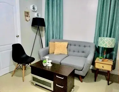 a living room with a couch and a table at Super Cute Hampton Suites in Imus