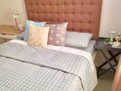 a bedroom with a bed and a side table at Super Cute Hampton Suites in Imus