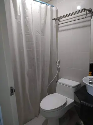 a bathroom with a toilet and a shower curtain at F-10C Parkside Villas in Manila