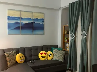 a living room with a brown couch with pillows at F-10C Parkside Villas in Manila
