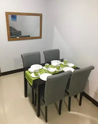 a dining room table with chairs and a mirror at F-10C Parkside Villas in Manila