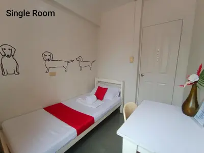 a small room with two beds with drawings on the wall at Bed and Brewhouse Sucat in Manila
