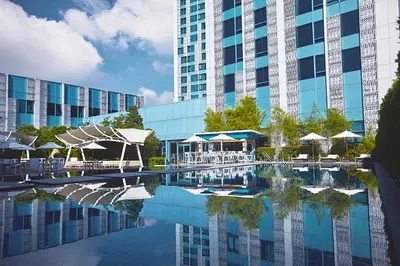 a large building with a pool of water in front of a building at Quest Plus Filinvest City Manila in Manila