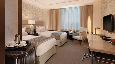 a hotel room with two beds and a desk at Quest Plus Filinvest City Manila in Manila