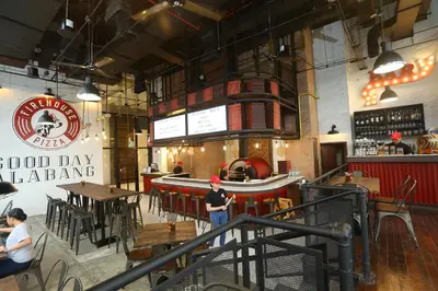 a man standing at a bar in a restaurant at Quest Plus Filinvest City Manila in Manila