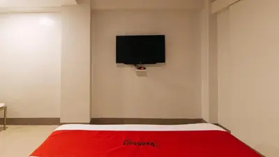 a bedroom with a red bed with a tv on the wall at RedDoorz at Samat Mandaluyong in Manila