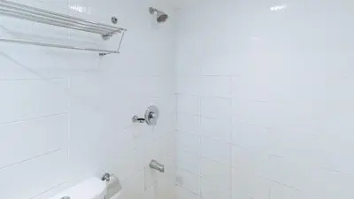 a bathroom with a shower with white tiles at RedDoorz at Samat Mandaluyong in Manila