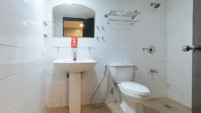 a white bathroom with a toilet and a sink at RedDoorz at Samat Mandaluyong in Manila