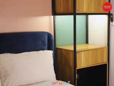 a bedroom with a bed and a book shelf at Citizen Hotel in Manila