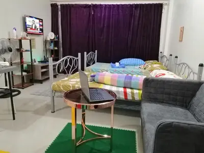 a living room with a couch and a laptop on a table at Condo Stay at Paranaque with Unlimited WIFI v3 in Manila