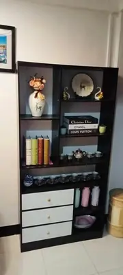 a black book shelf with books and other items at Estien's cozy home in Malagasang Primero