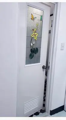 a door with a stained glass window with a butterfly on it at Estien's cozy home in Malagasang Primero
