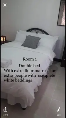 a bedroom with a bed with an extra floor mattress for extra people with complete white at Estien's cozy home in Malagasang Primero
