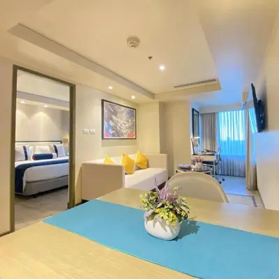 a hotel room with a bed and a living room at Seda Residences Makati in Manila