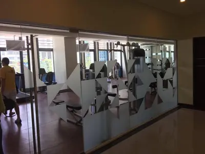 a room with a glass window with people in it at Affordable Cozy Pad in Salcedo Village Makati in Manila
