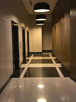 a hallway of a building with lights on the floor at Affordable Cozy Pad in Salcedo Village Makati in Manila