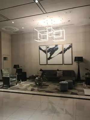 a living room with a couch and a chandelier at Affordable Cozy Pad in Salcedo Village Makati in Manila