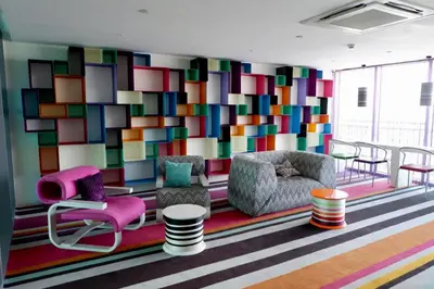 a room with chairs and a colorful wall at Great 1BR Aqua Livingstone with Netflix, Pool & Gym in Manila