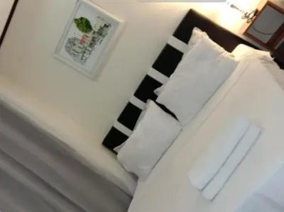 a bedroom with a bed with two pillows at Jen's Paranaque City Apartment in Manila