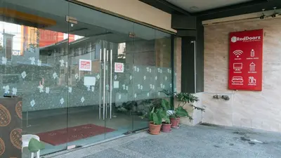 a store window with potted plants in front of it at RedDoorz Plus at Winter Benitez in Manila