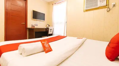 a hotel room with a bed with a red ribbon on it at RedDoorz Plus at Winter Benitez in Manila