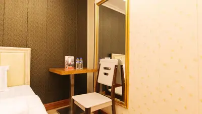 a bathroom with a mirror and a chair in a room at RedDoorz Plus at Winter Benitez in Manila