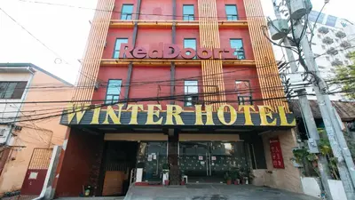 a red building with a sign for a winter hotel at RedDoorz Plus at Winter Benitez in Manila