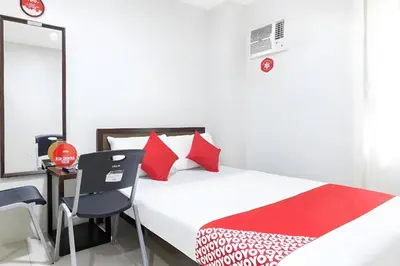 a bedroom with a bed and a desk and a chair at OYO 152 Sangco Condotel in Manila
