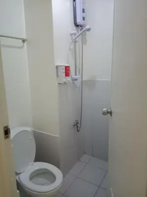 a white bathroom with a toilet and a shower at Urban Deca Tower OYO 3 in Manila