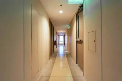 a hallway with white walls and a long hallway with white cabinets at Urban Deca Tower OYO 3 in Manila