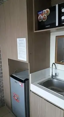 a small kitchen with a sink and a refrigerator at Urban Deca Tower OYO 3 in Manila