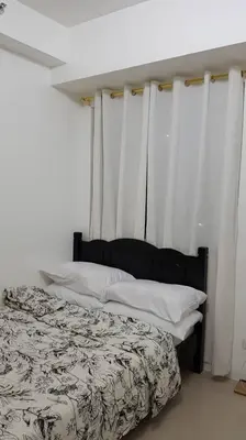 a bedroom with a bed with white curtains at 1 Bedroom Apartment @SMDC Shore Residences, Mall of Asia in Manila