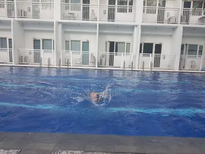 a pool of blue water in front of a building at 1 Bedroom Apartment @SMDC Shore Residences, Mall of Asia in Manila