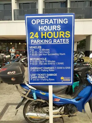 a sign on a motorcycle parked in a parking lot at 1 Bedroom Apartment @SMDC Shore Residences, Mall of Asia in Manila