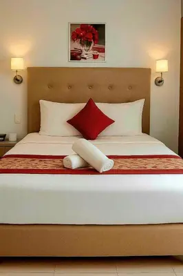 a bedroom with a large bed with red and white pillows at JMM Grand Suites in Manila