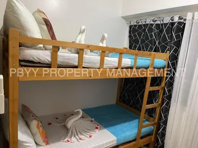 two bunk beds in a room with a ladder at Shore Residences, Mall Of Asia Complex Stays by PBYY in Manila