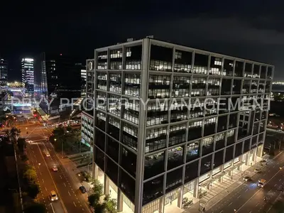 a tall building with lights on in a city at night at Shore Residences, Mall Of Asia Complex Stays by PBYY in Manila