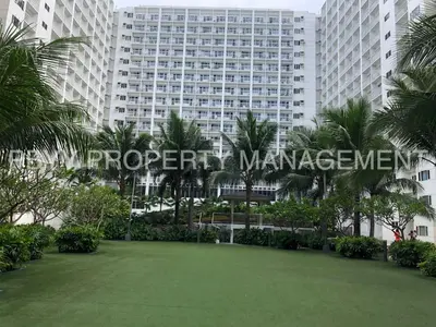 a large building with a green lawn in front of it at Shore Residences, Mall Of Asia Complex Stays by PBYY in Manila